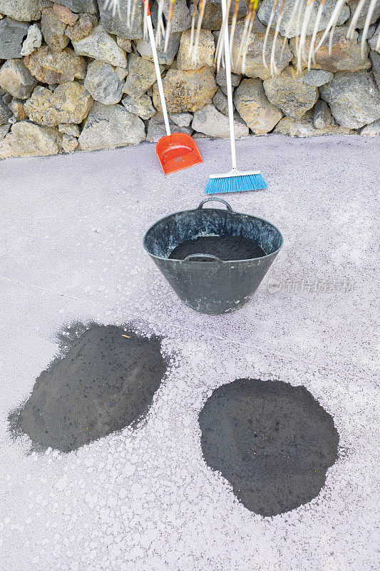 La Palma的灰烬，Cumbre Vieja火山的火山活动。用扫帚和篮子把整个岛都打扫干净。